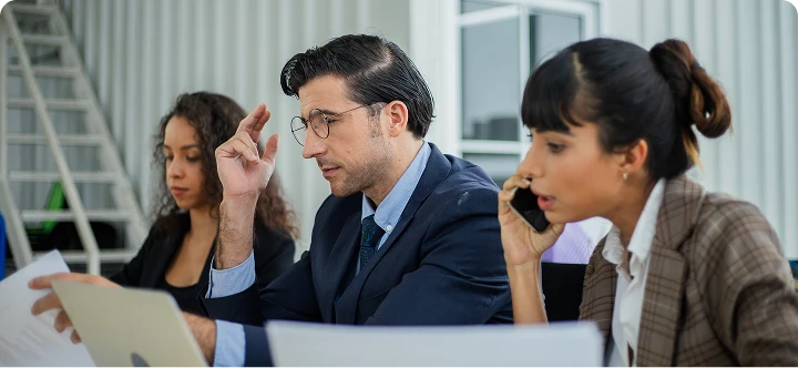 Engineer working on multiple computer screens with code